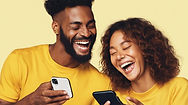 Two People Laughing Together Looking at Phones