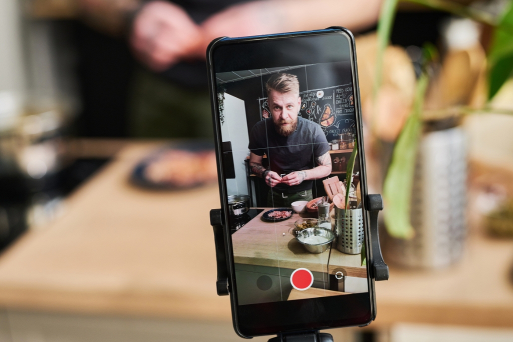 A phone screen shows it's recording a video with the subject in view on the screen.