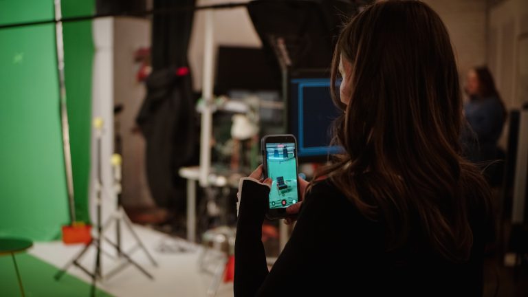 Someone takes a picture using their iPhone, we can see the screen of the phone and the back of their head.